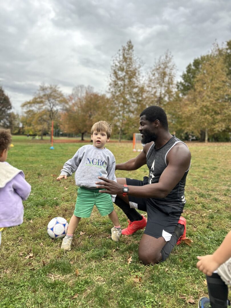 A kid being trained by a coach for playing football